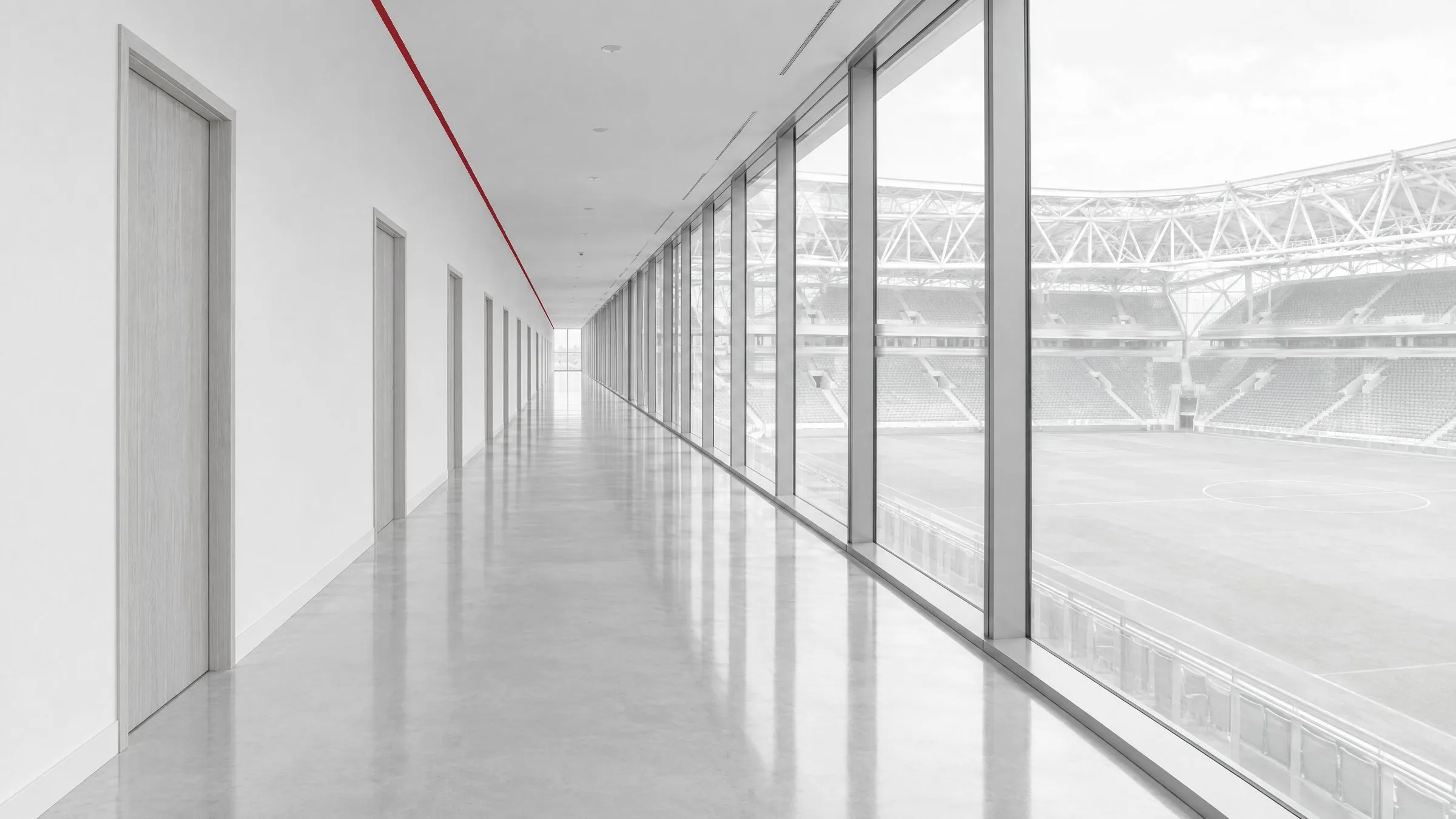 Long empty stadium corridor with a glass wall over the pitch
